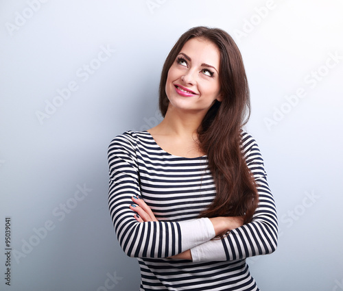 Happy thinking casual girl with folded hands looking up
