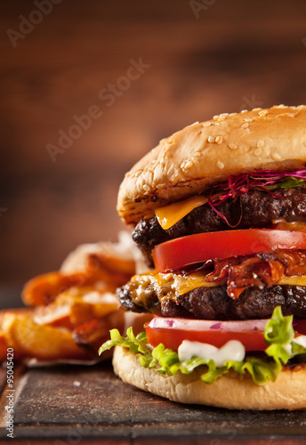 Obraz na plátně Delicious hamburger on wood