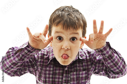 Kid making a face and showing his tongue. Isolated on white background
