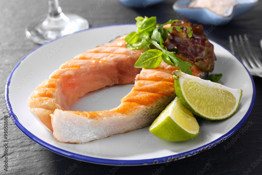 Tasty grilled salmon with greens on table close up Tasty grilled salmon with greens on table close up