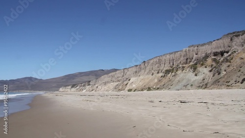 Jalama Beach Sandcliff and Shore / Panning from the Sand Cliffs of a California shore to the ocean and waves flowing onto the shoreline photo