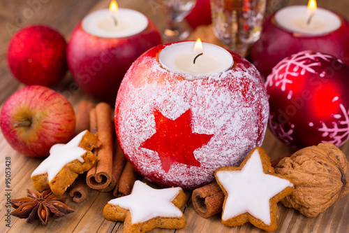 Christmas table decoration with candles in red apples