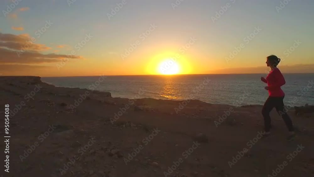 AERIAL SLOW MOTION: Woman jogging on top of ocean cliff AERIAL SLOW MOTION: Woman jogging on top of ocean cliff
