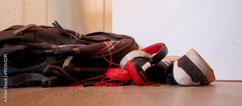 Backpacker casually resting . Shoes, headphones and a backpack thrown on the floor. Carefree mood and youthful spirit.