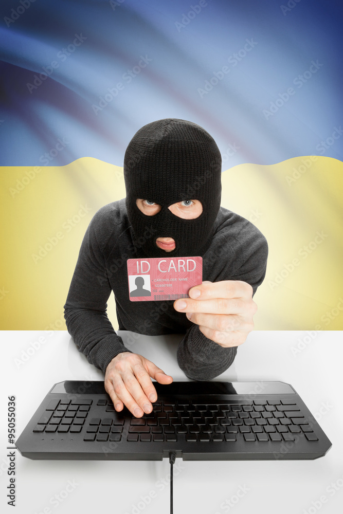 Hacker with flag on background holding ID card in hand - Ukraine Hacker with flag on background holding ID card in hand - Ukraine