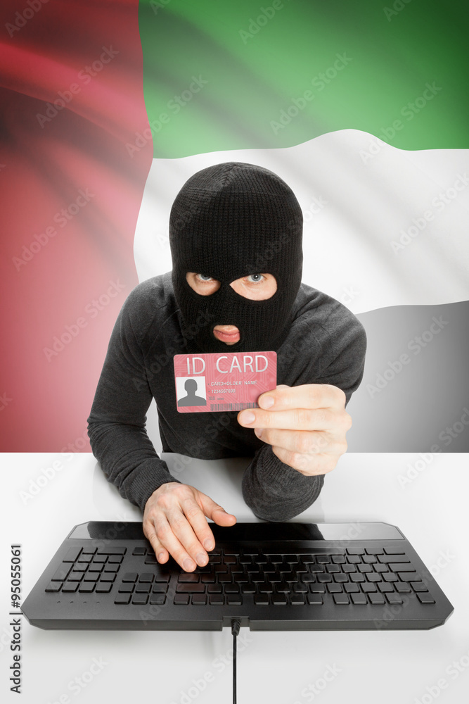Hacker with flag on background holding ID card in hand - United Arab Emirates Hacker with flag on background holding ID card in hand - United Arab Emirates