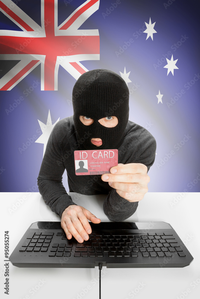 Hacker with flag on background holding ID card in hand - Australia Hacker with flag on background holding ID card in hand - Australia