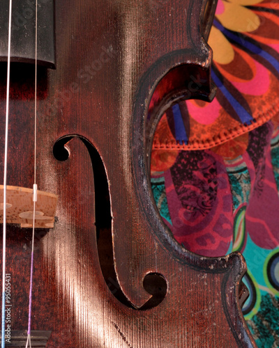 Antique violin closeup against bright print