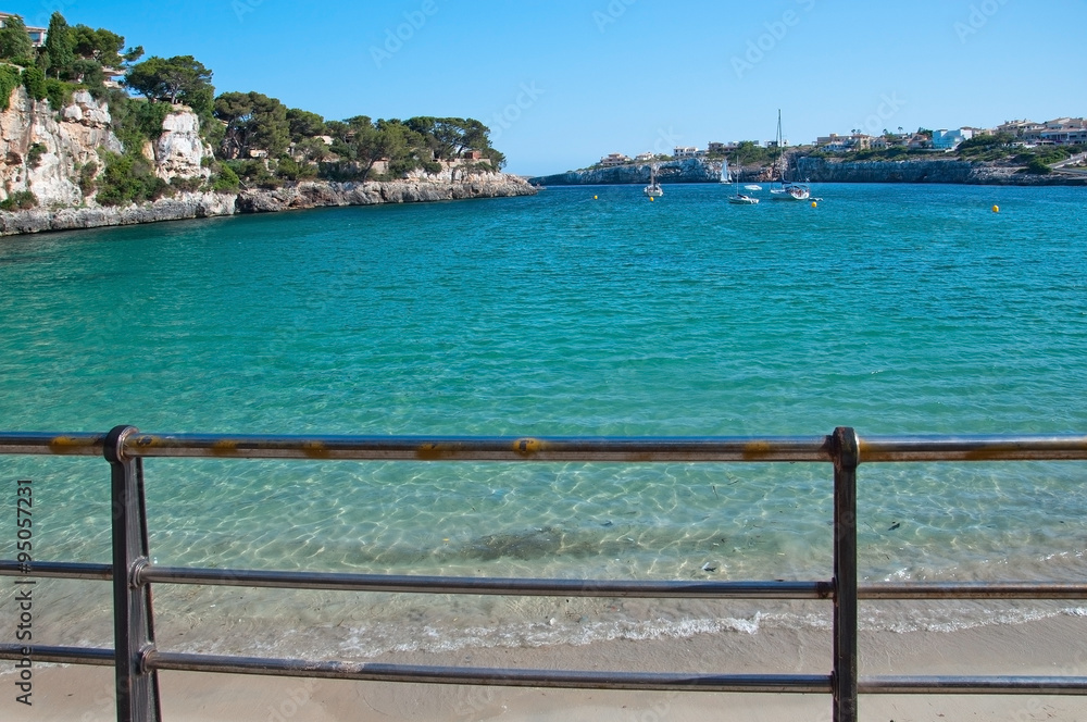 Beach in Porto Cristo with turquoise water and blue sky on a sunny summer day in Mallorca, Balearic islands, Spain. Beach in Porto Cristo with turquoise water and blue sky on a sunny summer day in Mallorca, Balearic islands, Spain.