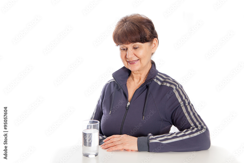 Good looking mature woman with glass of water posing after her sport session Good looking mature woman with glass of water posing after her sport session