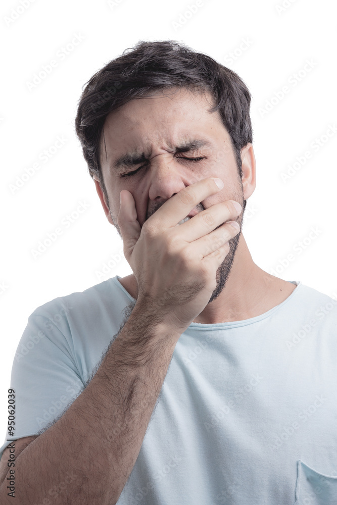 Young man yawning with his hand on face Young man yawning with his hand on face