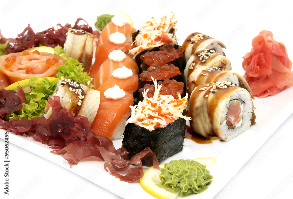 plate of sushi beautifully decorated with salad and fruit on a white background plate of sushi beautifully decorated with salad and fruit on a white background