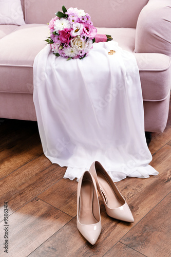 Wedding bouquet, bridesmaid dress and shoes in room