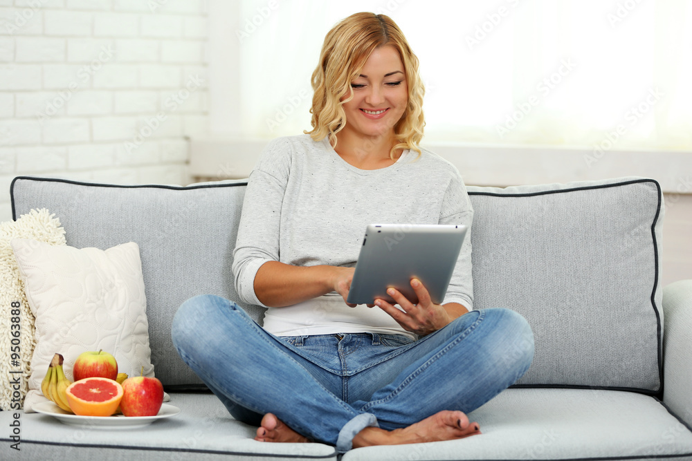 Beautiful woman with fresh fruits and digital tablet on home interior background Beautiful woman with fresh fruits and digital tablet on home interior background