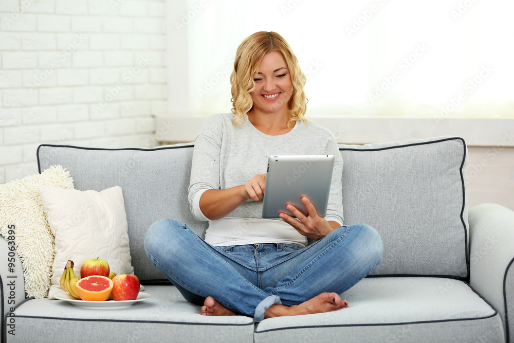Beautiful woman with fresh fruits and digital tablet on home interior background Beautiful woman with fresh fruits and digital tablet on home interior background