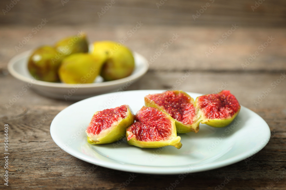 Ripe figs on plate, on wooden background Ripe figs on plate, on wooden background
