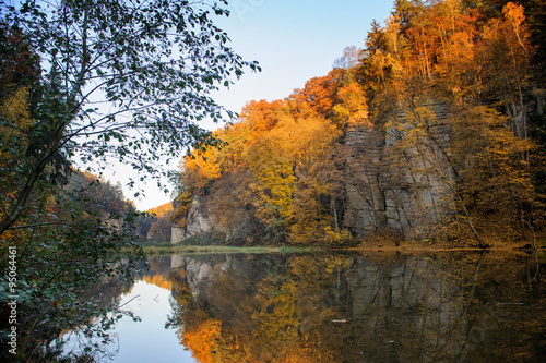 Fototapeta Naklejka Na Ścianę i Meble -  Vibrant colorful autumn landscape with rock and lake