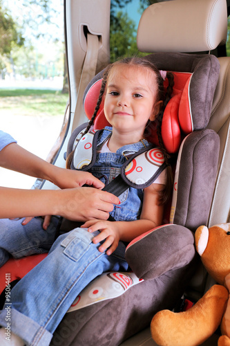 Cute little girl sitting in...