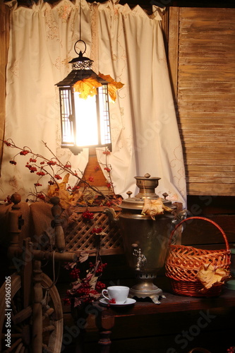 Samovar with a cup of tea. / Cup of tea and a Russian samovar under the light of a lantern. Autumn.
