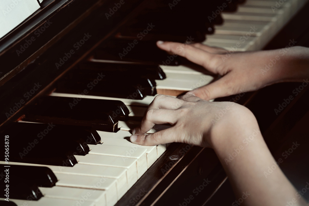 Fototapeta premium Close up of little girl hands piano playing