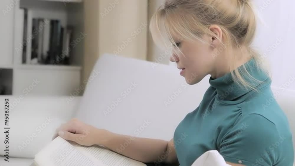 beautiful and elegant blonde woman reading a book at home on couch beautiful and elegant blonde woman reading a book at home on couch