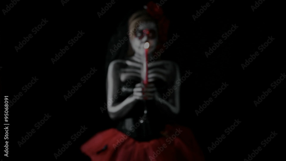 female sugar skull with red candle, is walking through the room female sugar skull with red candle, is walking through the room