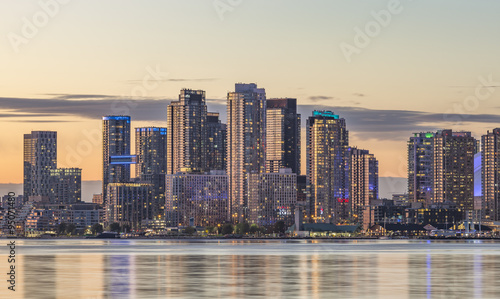  Toronto Harbourfront  district skyline with   the adjacent high-rise condo buildings - illuminated during sunset .