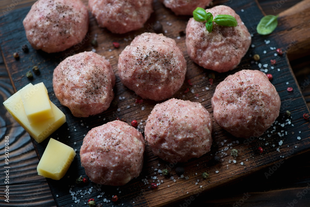 Close-up of uncooked meatballs with seasonings, high angle view Close-up of uncooked meatballs with seasonings, high angle view