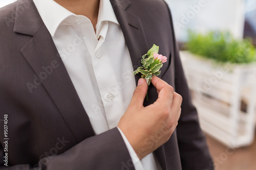 Boutonniere on trendy groom at wedding © uv_group