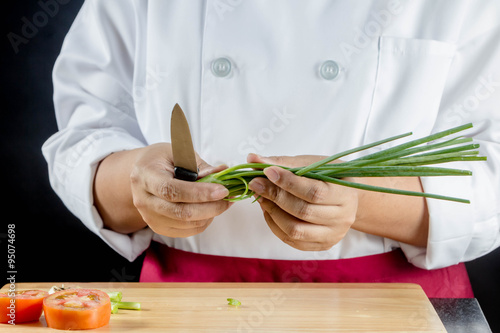chef chopped green onions or spring onions on wooden board