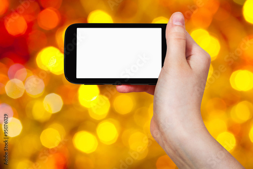 hand with smartphone on christmas background