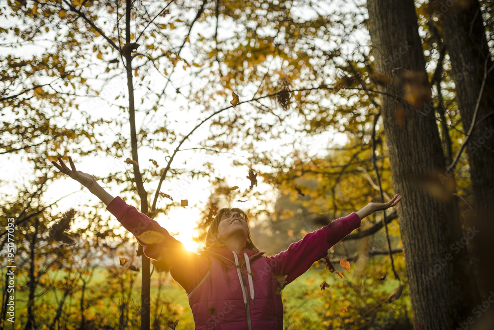 Young woman enjoying beautiful life and nature as she throws aut Young woman enjoying beautiful life and nature as she throws aut