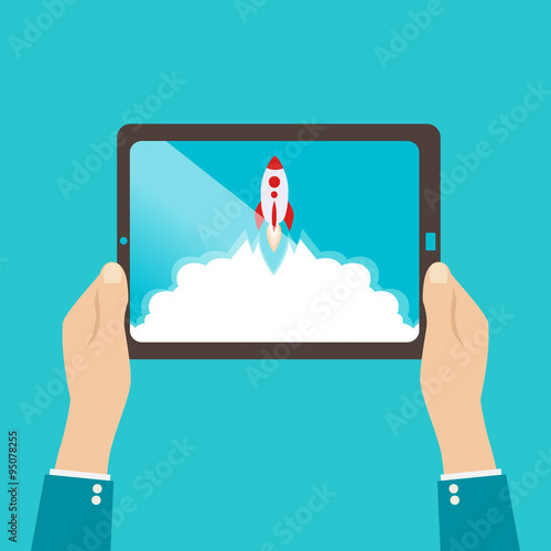 Start up business concept for mobile app development or other disruptive digital business ideas. Cartoon rocket launching from tablet. photo