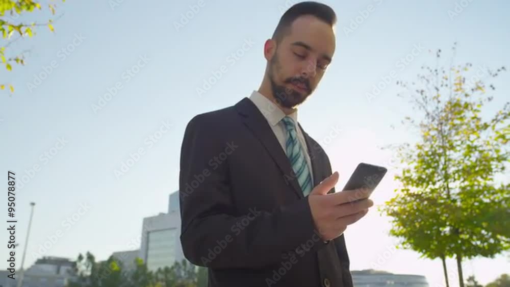 CLOSE UP: Businessman chatting on smartphone outdoors CLOSE UP: Businessman chatting on smartphone outdoors