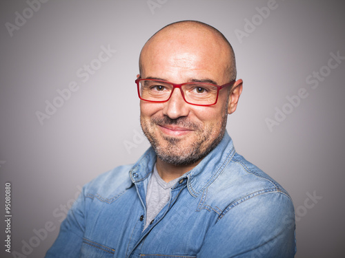 Hombre de cuarenta años con gafas rojas sonriendo photo