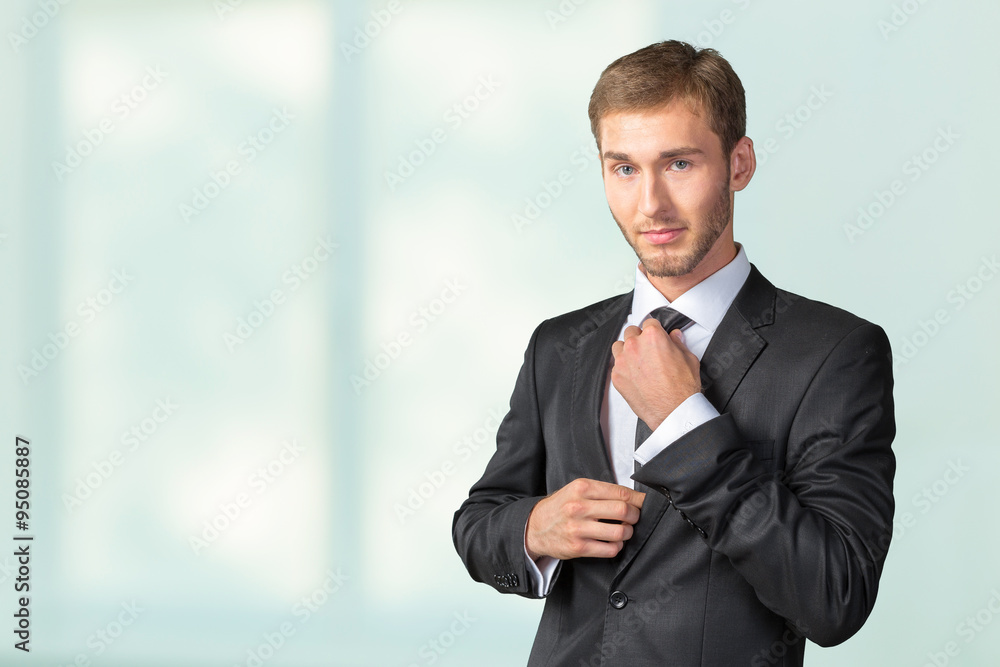 Young handsome businessman adjusting his tie Young handsome businessman adjusting his tie
