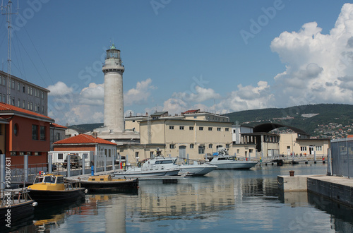 Lighthouse, motor boats in harbor in Trieste, Italy