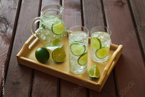 Obraz na płótnie Two drinks and jug on wooden tray with ice and condensation on g w salonie