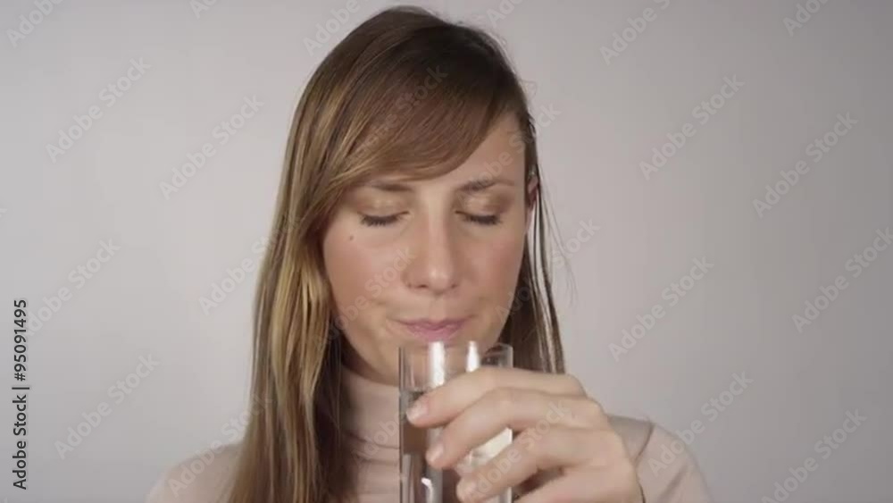 Young woman takes a pill and drinks water Young woman takes a pill and drinks water