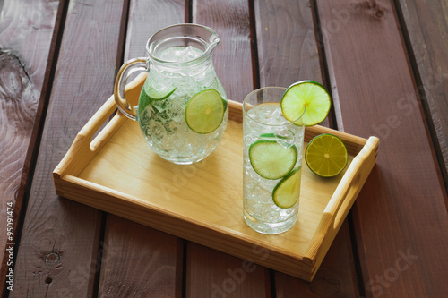 Obraz na płótnie Drink and jug on wooden tray with ice and condensation on glass w salonie
