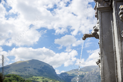 Fountain with drinking water over a mountain background - nature concept