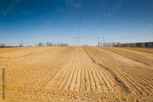 spring plowed field, over the field of high-voltage power line