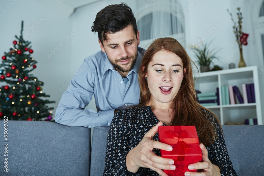 young couple is happy with gift for christmas young couple is happy with gift for christmas