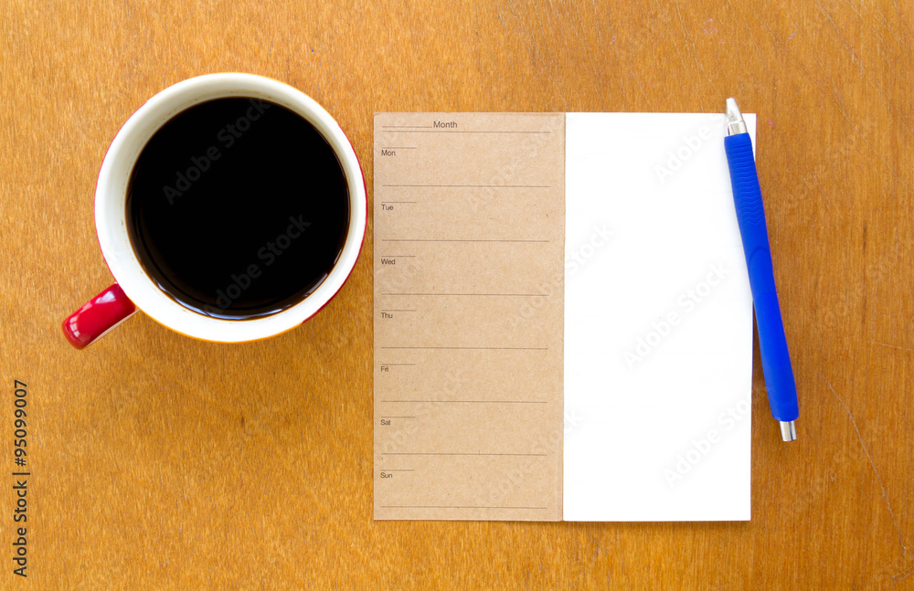 Memory blank notebook and blue pen with coffee on wooden background Memory blank notebook and blue pen with coffee on wooden background