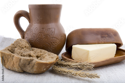 fresh milk, butter and rye bread in-kind pottery on linen tablec photo