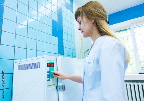 pharmaceutical factory woman worker operating autoclave for medi photo