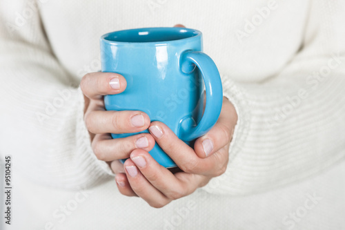 Cup of tea or coffee in female hands