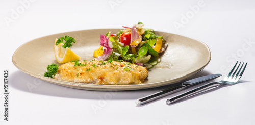 Fish fillet with vegetable salad isolated on white