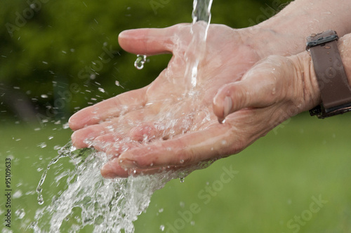 men's hands under running cold water