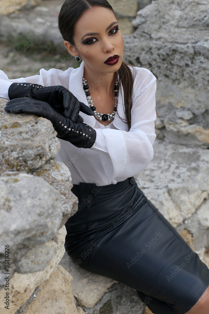 elegant woman with dark hair wears white shirt, black leather skirt and  gloves Stock Photo | Adobe Stock